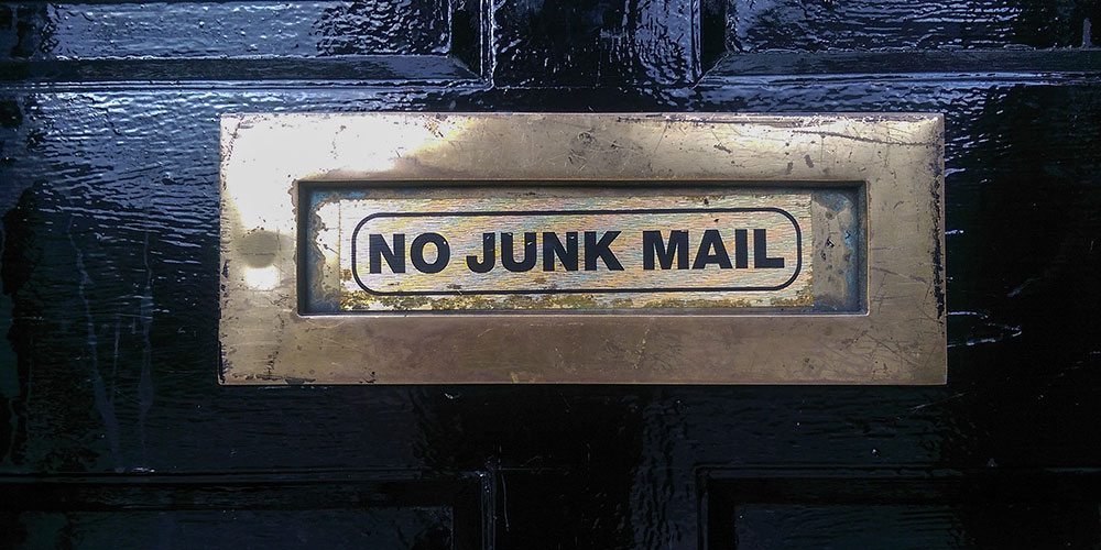 email deliverability header of a mail slot in door that reads "no junk mail"